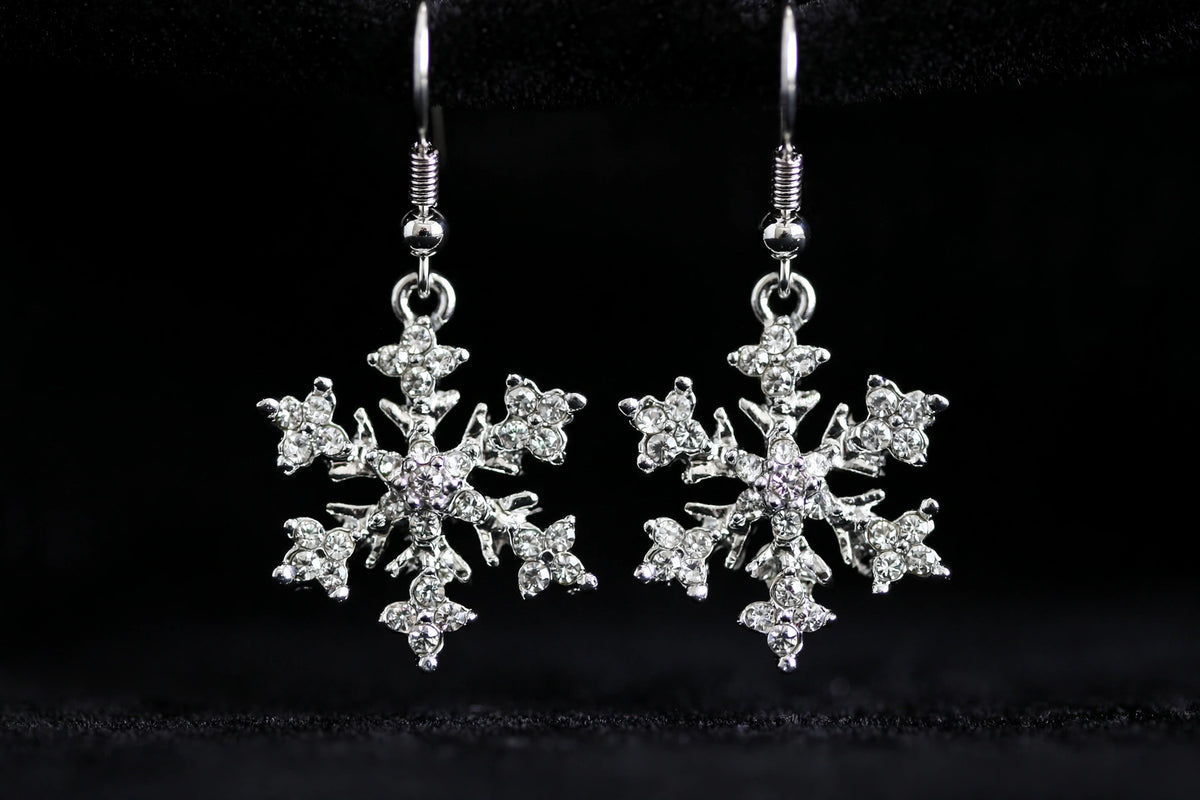 Silver-plated rhinestone snowflake dangle earrings, front view